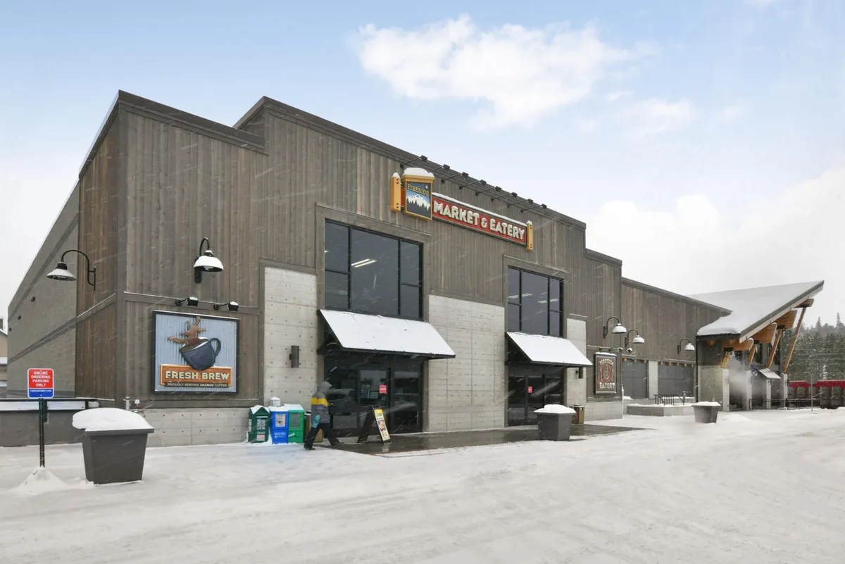 This exterior shot showcases a welcoming market entrance with clear signage, entrance doors, and a snow-covered ground, suggesting proximity to local amenities and outdoor experiences. The wintery setting underscores the appeal of exploring the area with pets, indicating easy walks to community spots even in colder weather.